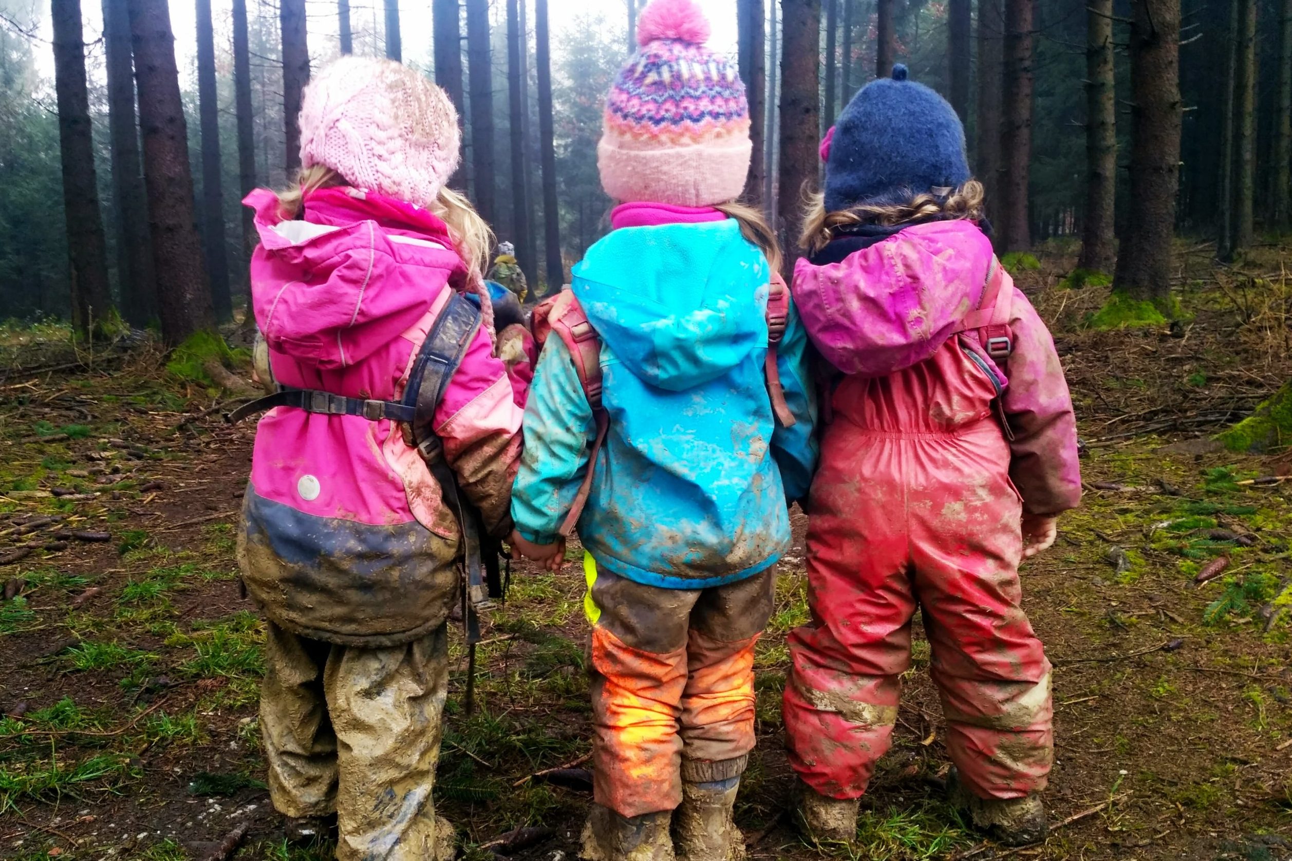 Kinder basteln mit Blättern und Naturmaterialien auf dem Waldboden