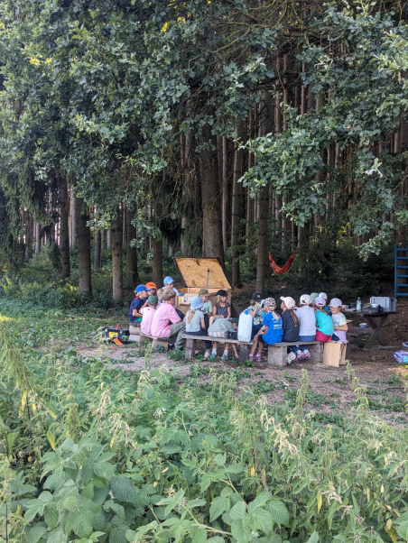 Kinder halten Hände über ein kleines Lagerfeuer